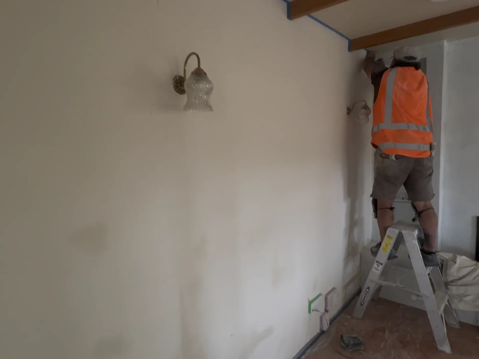 Painter applying a fine finish to interior walls and trim