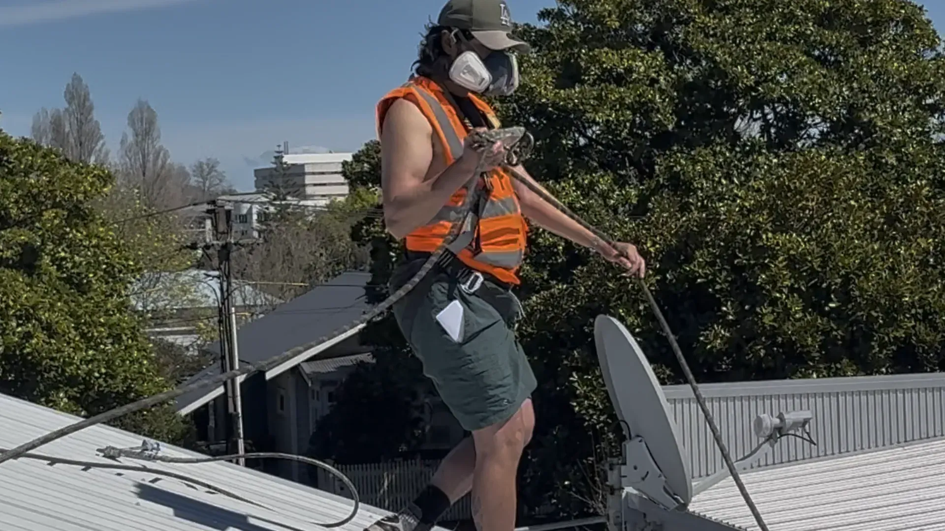 Roof restoration technician cleaning a long-run iron roof in Tauranga