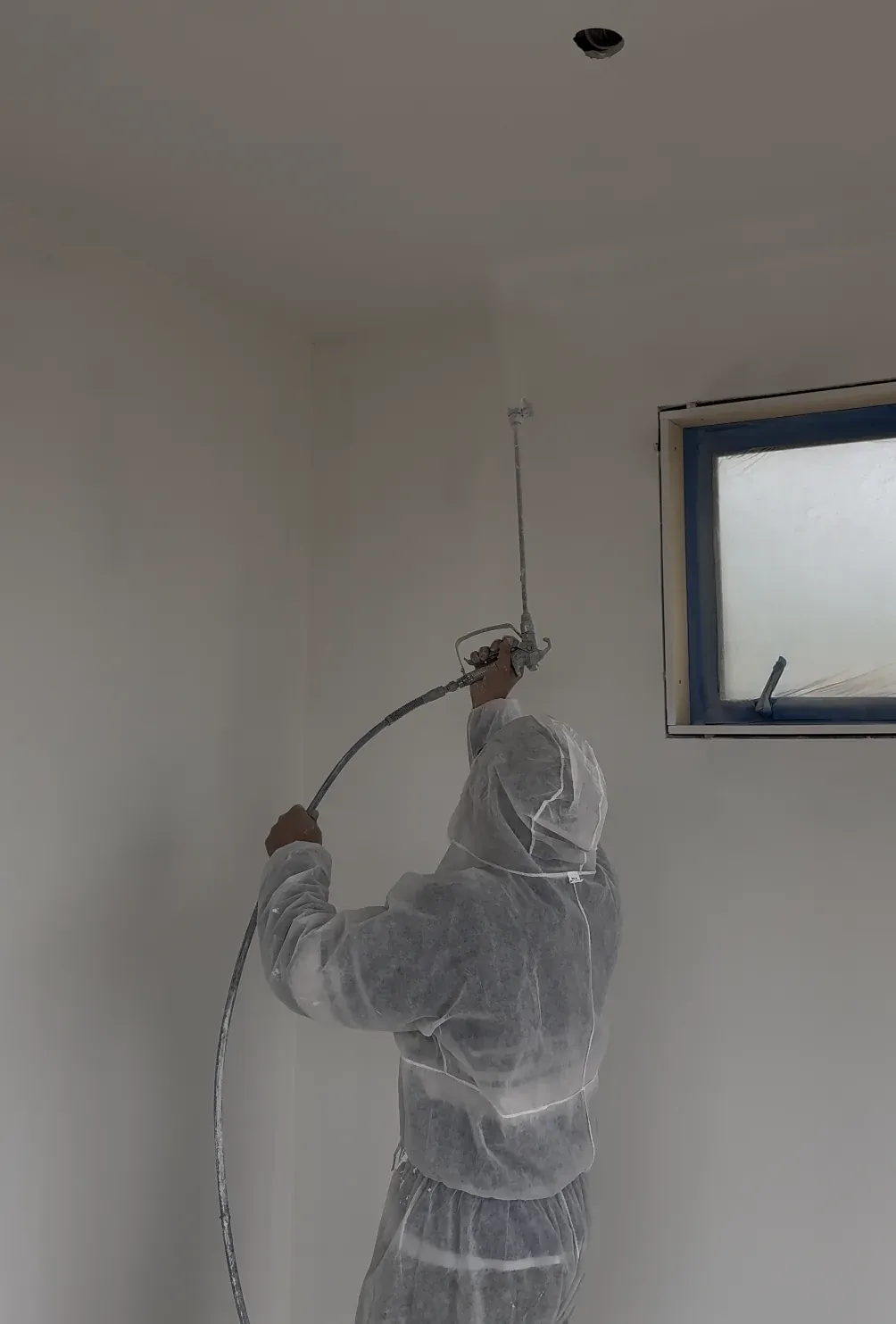 Airless spray painter applying a smooth finish